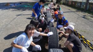 タイヤ遊具にペンキを塗る上溝小学校の児童たち